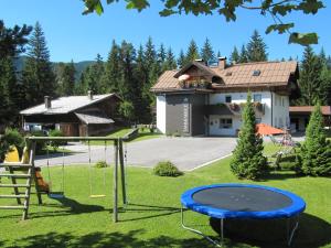 un parco giochi in un cortile con una casa di Ferienhaus Tannenblick a Leutasch