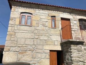 a stone building with two windows and a balcony at Casa da Chã! in Chã