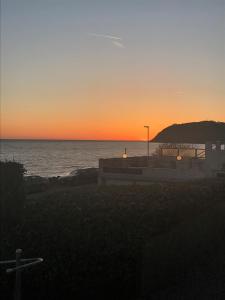 a sunset over the ocean with a cross in the foreground at Pensionat Strandgården in Mölle