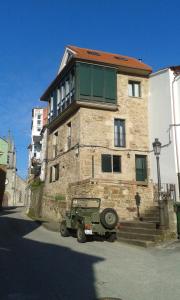 un veicolo militare parcheggiato di fronte a un edificio di Casa taller de Benito a Corcubión