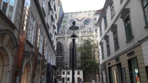 un callejón en una ciudad con edificios y un semáforo en At St. Stephan, en Viena