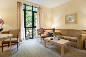 a living room with a couch and chairs and a table at Espahotel Plaza Basílica in Madrid