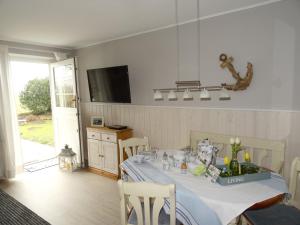 a dining room with a table with chairs and a television at Hansenhof in Kappeln