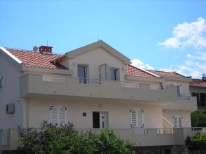 a white house with red tile roofs at Apartments Stanjević in Tivat
