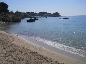 a beach with a body of water with rocks in it at Summer Beach Rooms in Fontane Bianche
