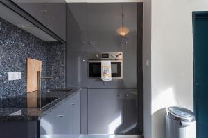 a kitchen with gray cabinets and a stove top oven at Chiado Bairro Alto, Bright and Newly Renovated 3 Bedroom Apartment, Lisbon Historical Center in Lisbon