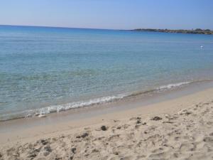 a sandy beach with the ocean in the background at Summer Beach Rooms in Fontane Bianche