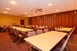 una sala de conferencias con mesas y sillas y ventilador de techo en Americas Best Value Inn Iola, en Iola