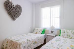 a bedroom with two beds and a heart on the wall at Chalet Parque Tecnológico in Campanillas