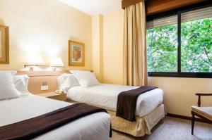 a hotel room with two beds and a window at Espahotel Plaza Basílica in Madrid