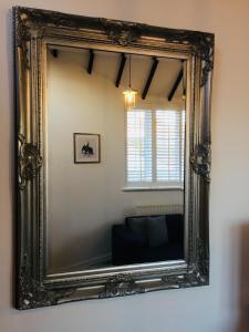 un espejo ornamentado en una pared de una habitación en Kenilworth Cosy Garden View Apartment, en Kenilworth