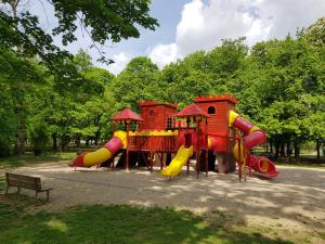 a playground with a slide in a park at La Boheme Apartman in Miskolc