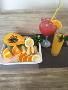 a plate of fruit and a drink on a table at Hotel POUSADA Brava in Vila Nova Sintra