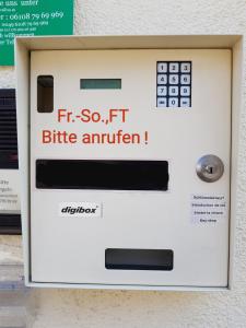 una máquina atm con las palabras, si es así, antígeno de picadura de frita en Hotel Gartenhof, en Mühlheim am Main