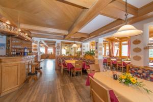 um restaurante com mesas e cadeiras e um bar em Hotel Naggler Weissbriach em Weissbriach