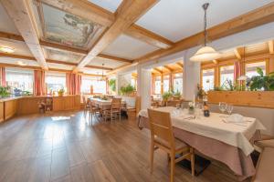 ein Esszimmer mit Tischen, Stühlen und Fenstern in der Unterkunft Hotel Naggler Weissbriach in Weissbriach