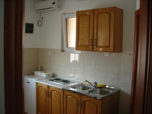 a kitchen with a sink and a stove and cabinets at Apartments Stanjević in Tivat