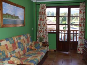 salon z kanapą i oknami w obiekcie Apartamentos La Corraliza w mieście Totero
