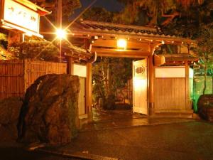 ein kleines Gebäude mit einem Tor in der Nacht in der Unterkunft Atami Onsen Sakuraya Ryokan in Atami