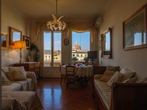 a living room with a chandelier and a table and chairs at Ponte Vecchio Terrace in Florence