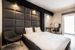 ポズナンにあるSuper-Apartamenty Exclusiveのベッドルーム(大型ベッド1台、椅子付)