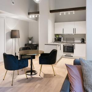 eine Küche und ein Wohnzimmer mit einem Tisch und Stühlen in der Unterkunft Frogner House - Bygdøy Allé in Oslo