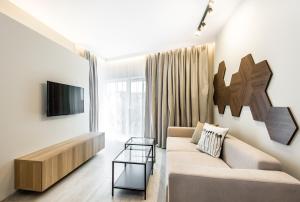 - un salon avec un canapé et une télévision dans l'établissement Super-Apartamenty Exclusive, à Poznań