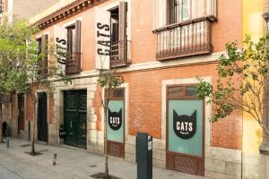 マドリードにあるCats Hostel Madrid Solのネコの看板が貼られたレンガ造りの建物