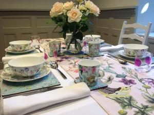 uma mesa com uma toalha de mesa com um vaso de flores em Grosmont House em Grosmont