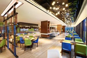 a restaurant with tables and chairs and a cafeteria at Hampton By Hilton Foshan Sanshui in Foshan