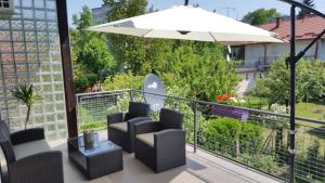 a balcony with chairs and a table and an umbrella at Apartman TARA in Zagreb