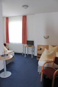 a room with a bed and a desk with a computer at Hotel Garni Meeresgruß in Sassnitz