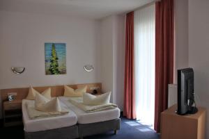 a living room with a couch and a tv at Hotel Garni Meeresgruß in Sassnitz