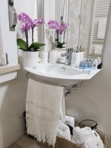 a bathroom with a sink with flowers and towels at Appartamento Via Acquati 12 - Monolocale 2 in Cormano