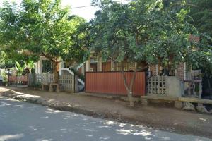 a house with a fence next to a street at Silent Night Homestay in Ella
