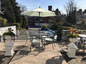 een patio met tafels en stoelen en een parasol bij Ennislare House Guest Accommodation in Bangor