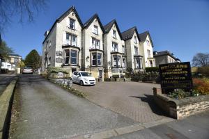 a white car parked in front of a large house at Brialene Holiday Flats in Scarborough