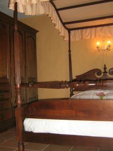 1 dormitorio con cama de madera y dosel en B&B Ter Castaigne en Koekelare