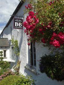 a white building with a sign and flowers on it at Low Fell in Ulverston