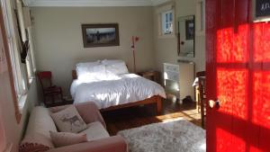 a living room with a bed and a couch at Little Red School House in Oamaru