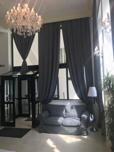 a living room with a couch and a chandelier at Hotel Arizona in Timişoara