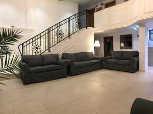 蒂米什瓦拉的住宿－Hotel Arizona，客厅设有两张沙发和一个楼梯