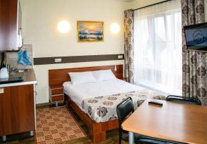 a hotel room with a bed and a table and a kitchen at Guest House on Lermontova 8 in Sochi
