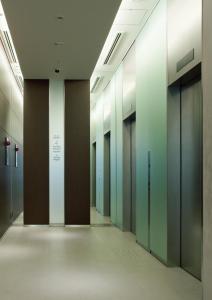 un corridoio vuoto di un edificio per uffici con porte in vetro di Fraser Residence Nankai Osaka ad Osaka