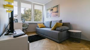 グダニスクにあるApartament Gdańsk Przymorzeのリビングルーム(ソファ、デスク、コンピュータ付)