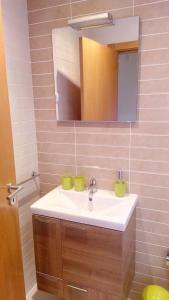 ein Badezimmer mit Waschbecken und Spiegel in der Unterkunft Casa Aromas do Mar, Burgau in Burgau