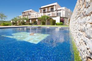 a swimming pool in front of a house at Geranio in L'Ampolla