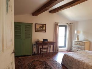 a bedroom with a desk and a bed and a table at Les Gites de Catherine in Gargas