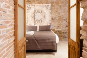 sypialnia z łóżkiem i ceglaną ścianą w obiekcie Ferreries Boutique Apartment w mieście Girona