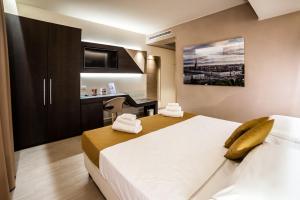 Caramagna PiemonteにあるHotel Terre Dei Saliciのベッド2台とデスクが備わるホテルルームです。